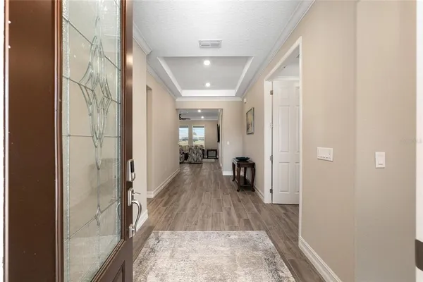 a living room with furniture kitchen view and a chandelier