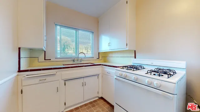 a kitchen with granite countertop cabinets stainless steel appliances and a window