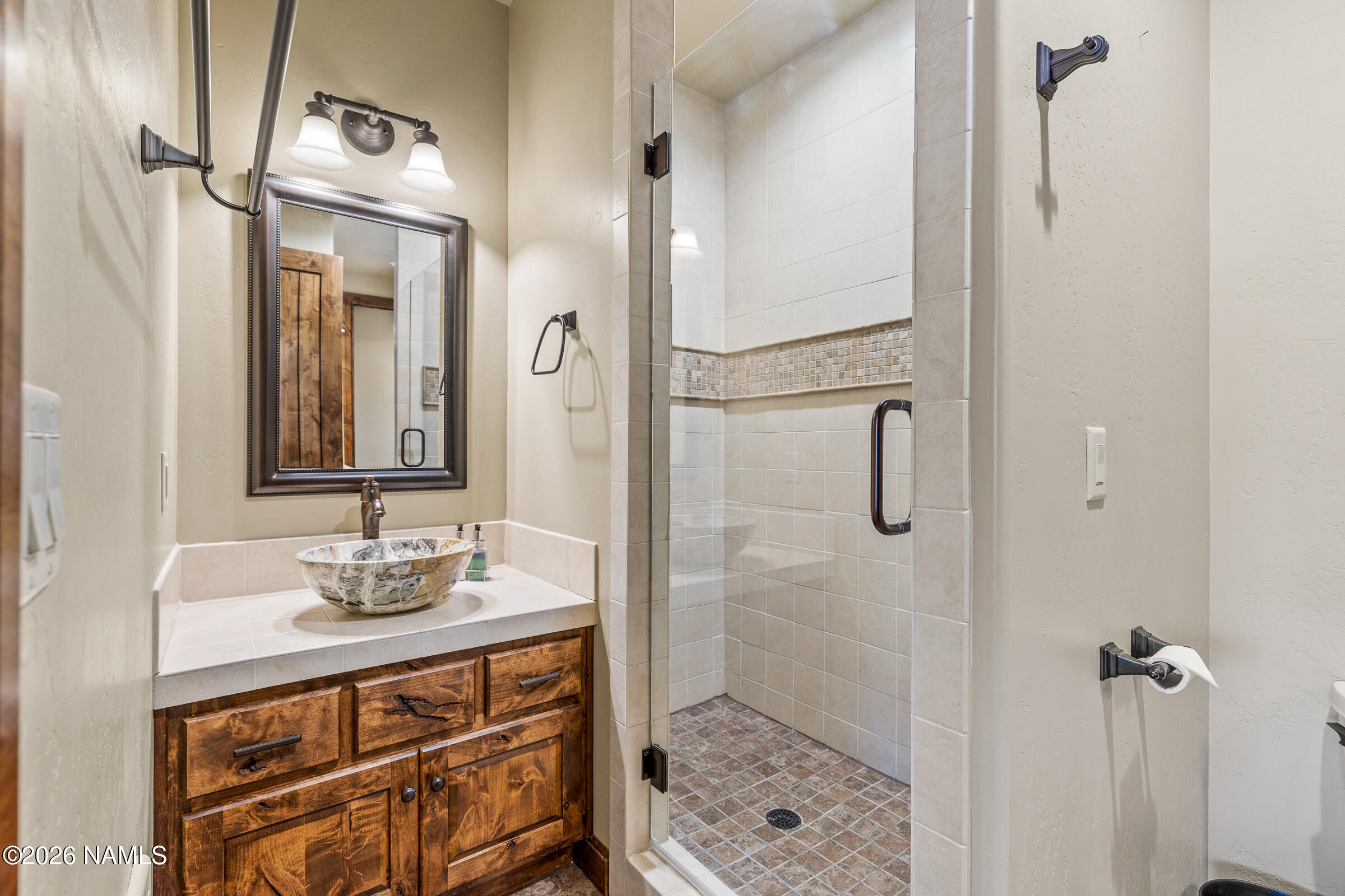 2214 East Del Rae Drive Flagstaff, AZ 86005 - Photo 27 of 45 a bathroom with a sink a mirror a vanity and shower