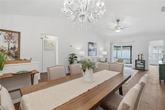 a view of a dining room with furniture a chandelier and wooden floor