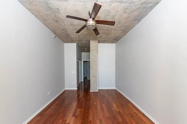 a view of room with hardwood floor and hallway
