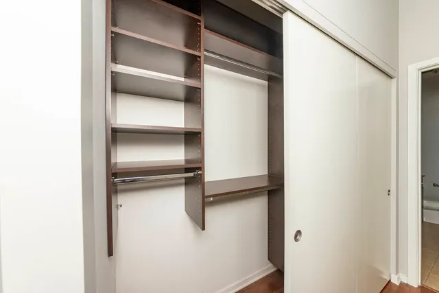 a view of walk in closet with empty racks