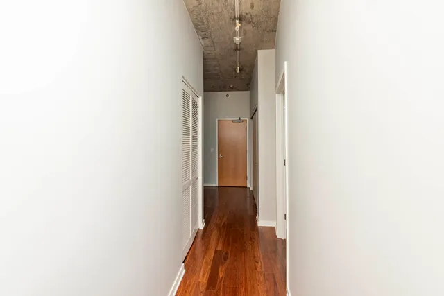 a view of a hallway with wooden floor