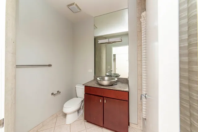 a bathroom with a granite countertop sink toilet a mirror and shower