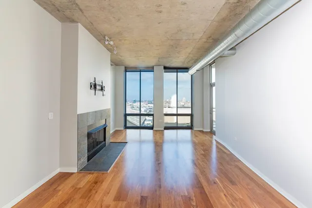 a view of empty room with wooden floor and fireplace