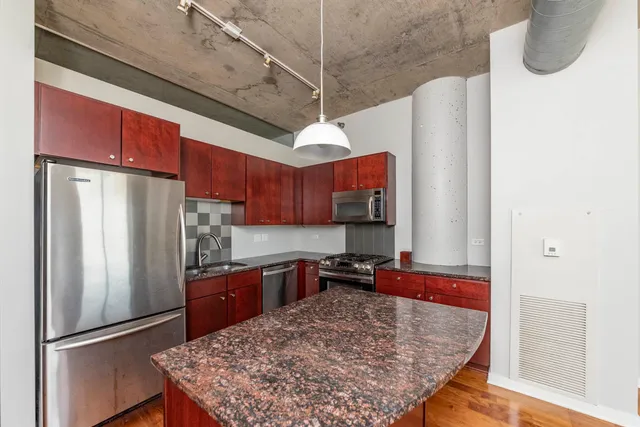 a kitchen with stainless steel appliances granite countertop a refrigerator a sink dishwasher a stove and a refrigerator