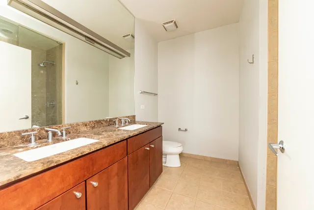 a bathroom with a granite countertop sink toilet and shower