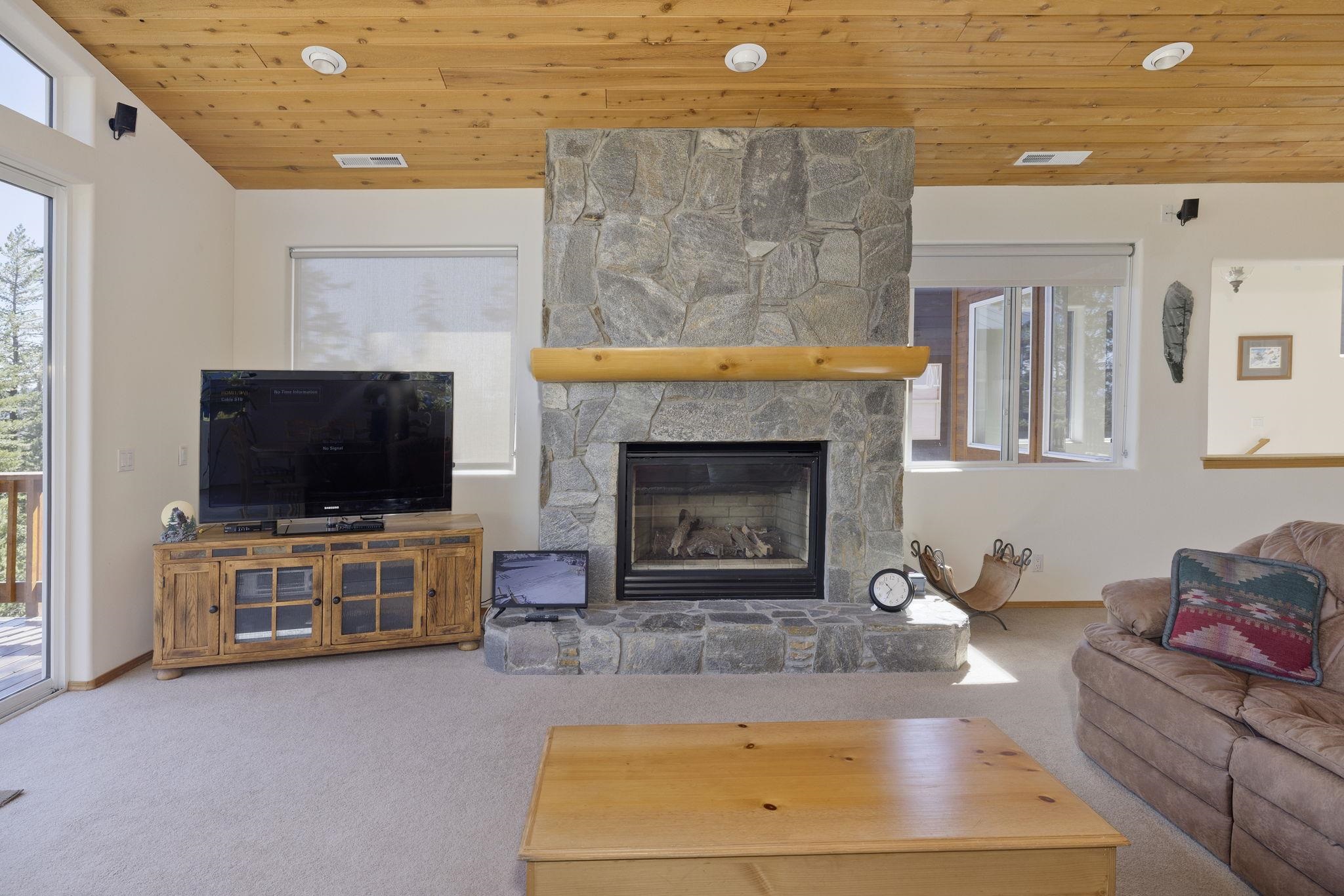 492 John Muir Road Mammoth Lakes, CA 93546 - Photo 14 of 33 Stone-clad fireplace with a log mantel and hearth, wood-paneled ceiling, and recessed lighting