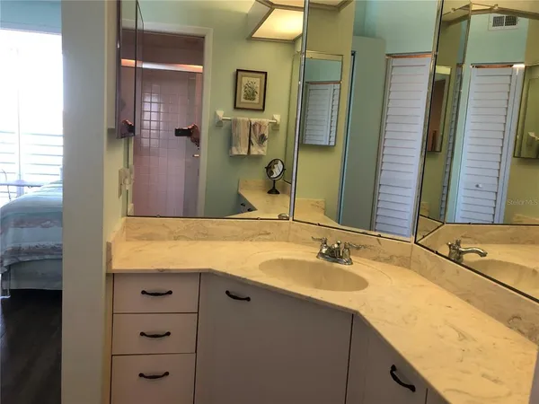 a bathroom with a granite countertop sink and a mirror