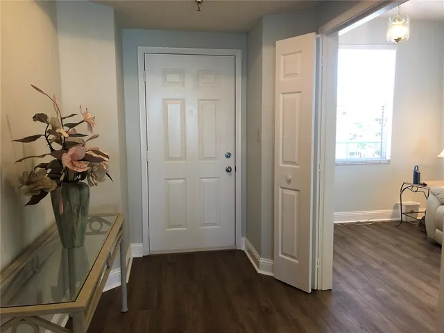 a view of a hallway with wooden floor and a livingroom view