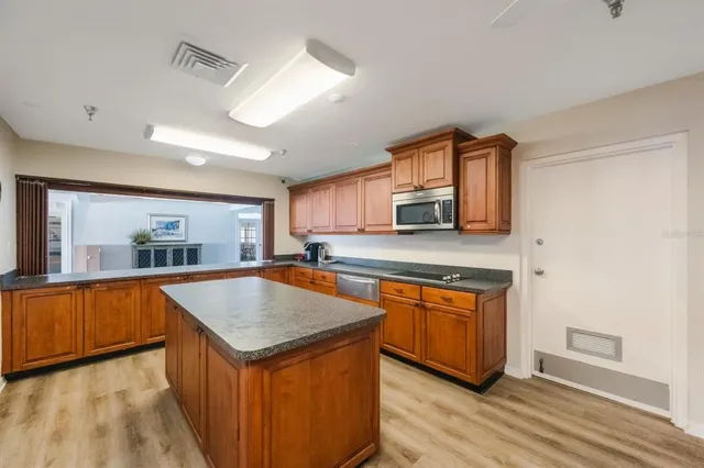 a kitchen with stainless steel appliances granite countertop a refrigerator a stove and a sink
