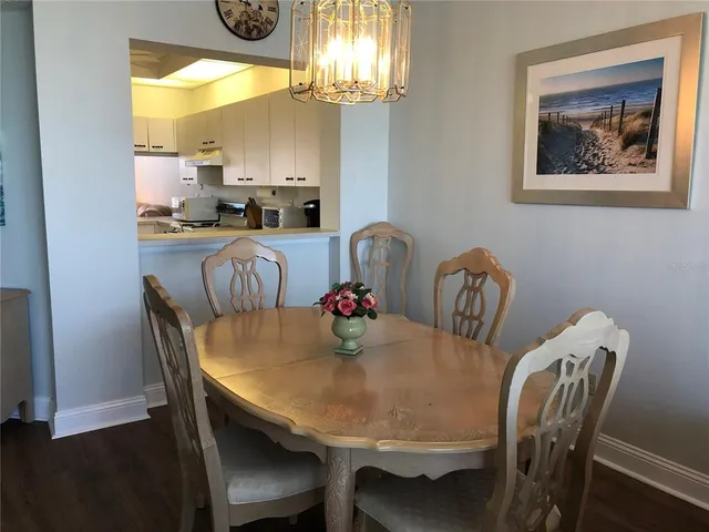a view of a dining room with furniture a chandelier and wooden floor