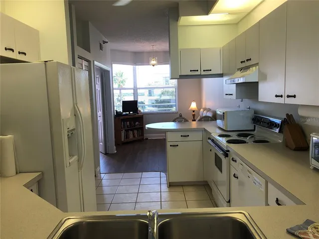 a kitchen with stainless steel appliances granite countertop a refrigerator a stove and a sink