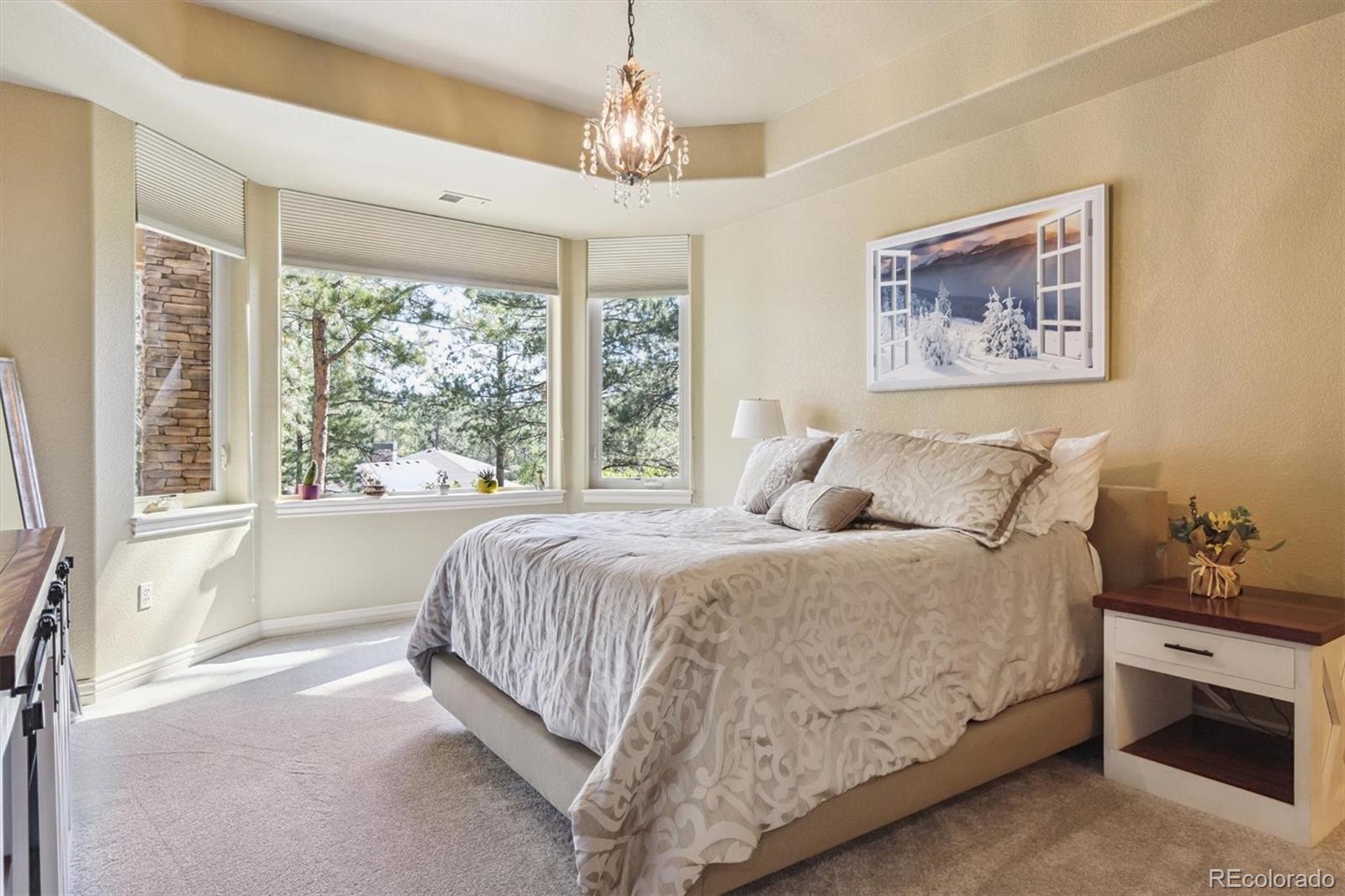 7994 Monarch Road Larkspur, CO 80118 - Photo 29 of 48 a spacious bedroom with a bed and a large window