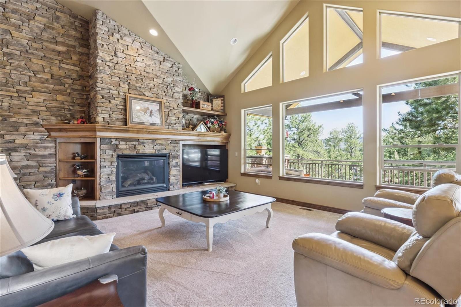 7994 Monarch Road Larkspur, CO 80118 - Photo 4 of 48 a living room with furniture a fireplace and a large window