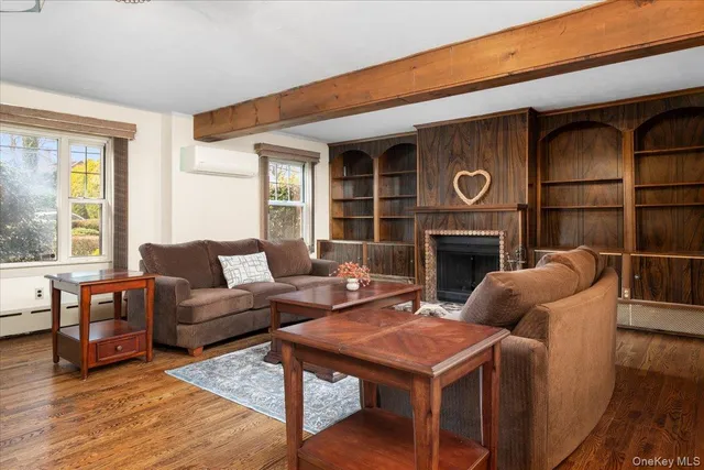 a living room with furniture a fireplace and wooden floor