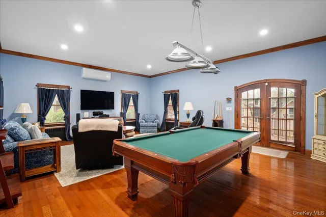 a room with furniture pool table flat screen tv and a rug