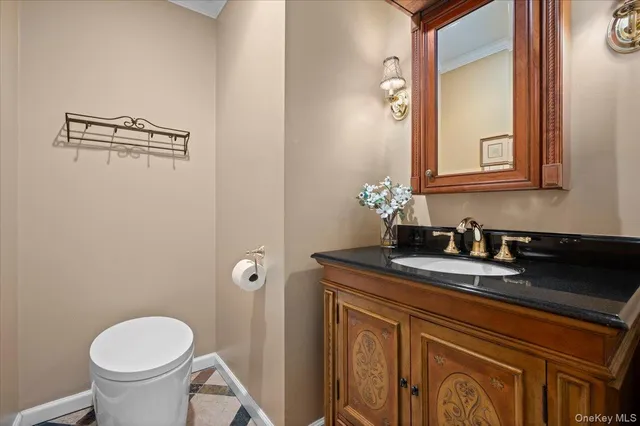a bathroom with a granite countertop sink toilet and mirror