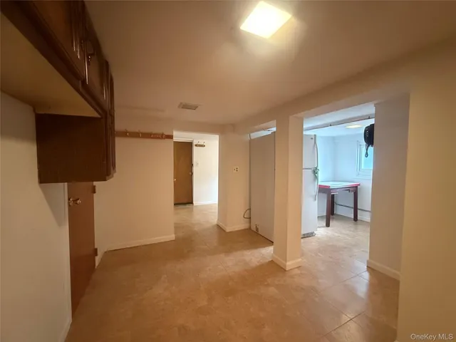 a view of a hallway with wooden floor and a cabinet