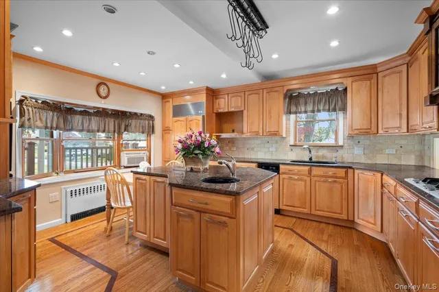 a kitchen with stainless steel appliances granite countertop a sink a stove a refrigerator cabinets and dining table