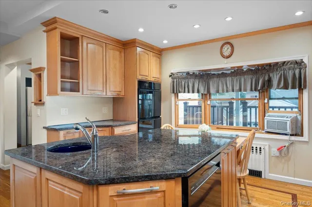 a kitchen with stainless steel appliances granite countertop a sink a stove and a wooden cabinets