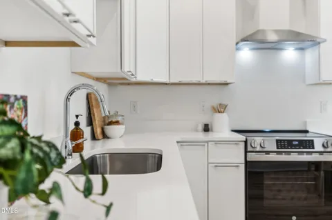 a kitchen with stainless steel appliances granite countertop a sink stove and cabinets