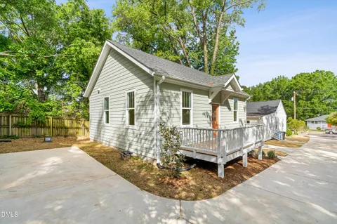 a view of a house with a patio and a yard