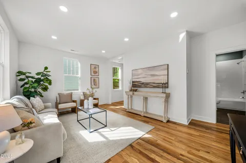 a living room with furniture appliances and wooden floor