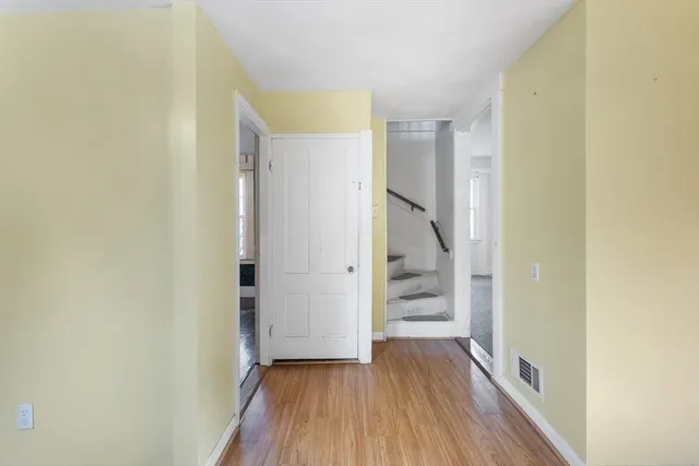 a view of a hallway with wooden floor and entryway