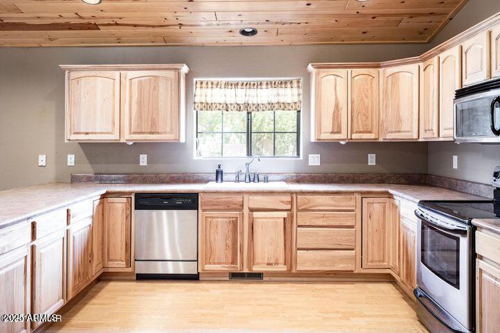 3244 Outlaw Trail Overgaard, AZ 85933 - Photo 12 of 29 a kitchen with granite countertop a sink stainless steel appliances white cabinets and a window