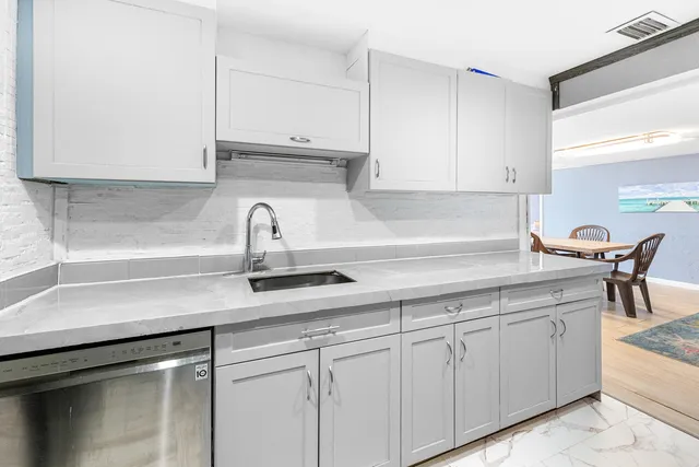 a kitchen with white cabinets and a sink