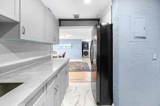 a kitchen with granite countertop a refrigerator and a sink