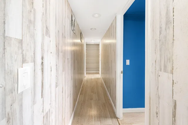 a view of a hallway with wooden floor
