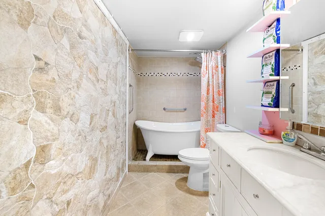 a bathroom with a sink toilet mirror and shower