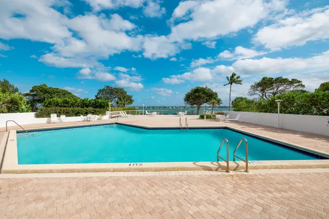 a view of a patio with table and chairs potted plants with large tree