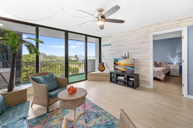 a living room with furniture and a large window with garden view
