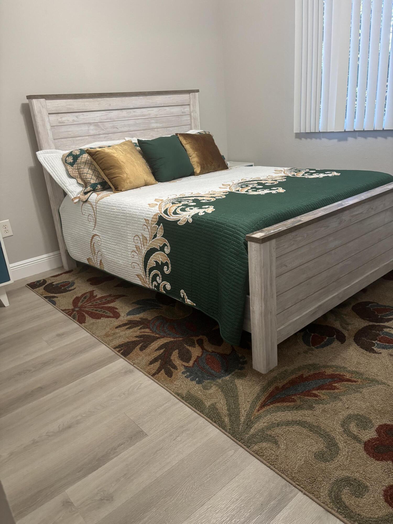 350 Crestwood Circle, Unit 106 Royal Palm Beach, FL 33411 - Photo 12 of 28 a bed sitting in a bedroom next to a window