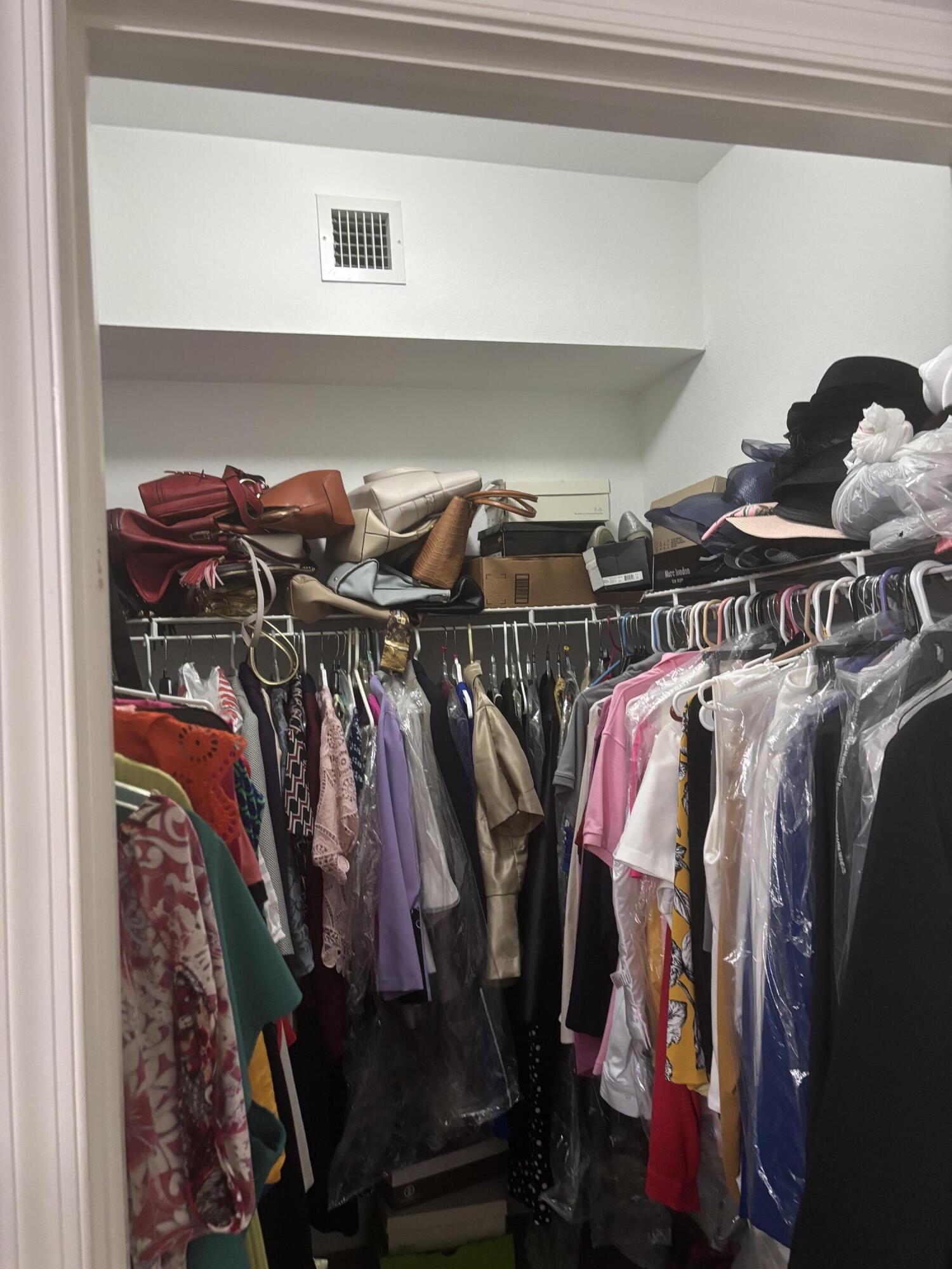 350 Crestwood Circle, Unit 106 Royal Palm Beach, FL 33411 - Photo 27 of 28 a view of walk in closet with clothes and shoes
