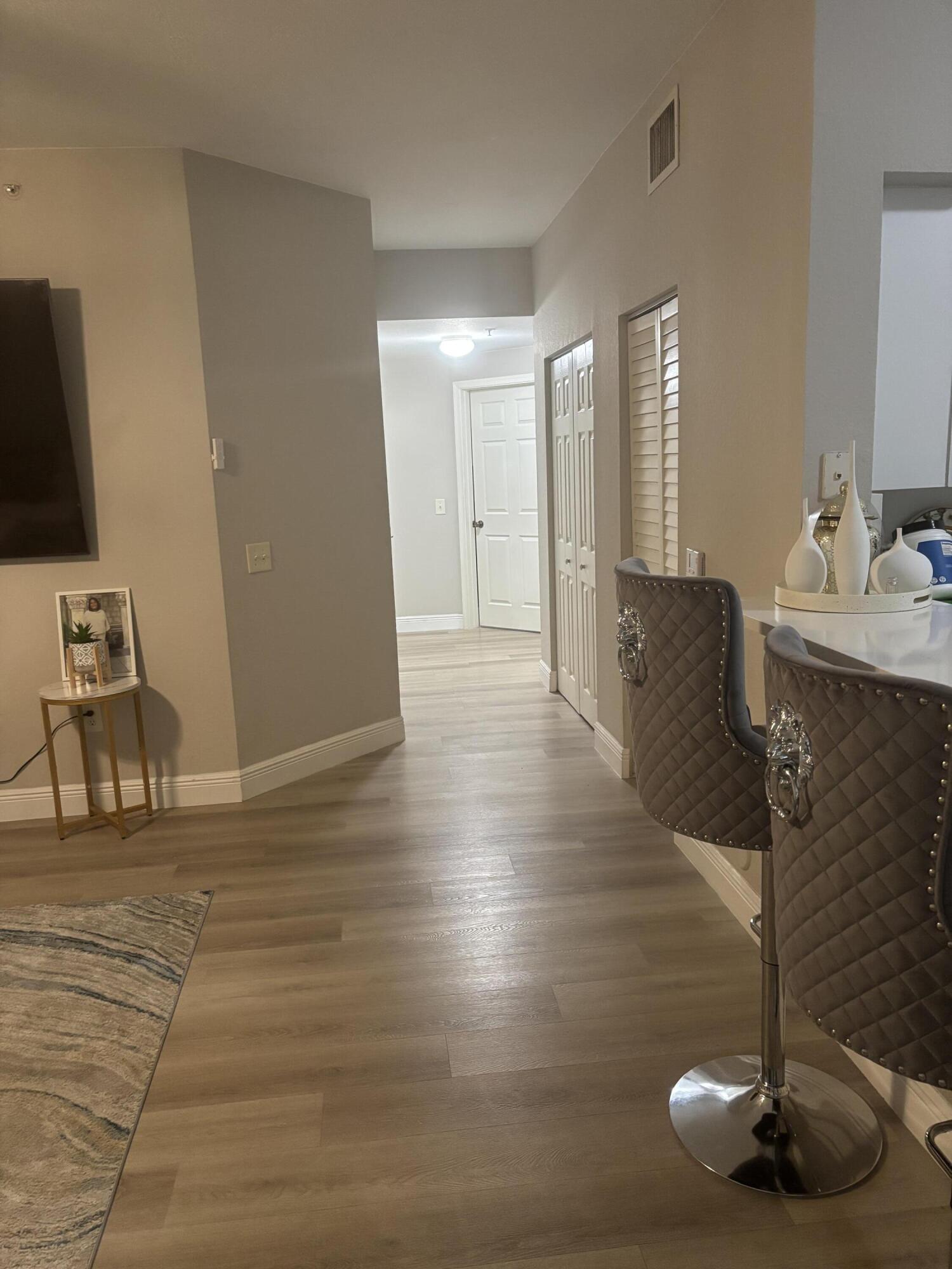350 Crestwood Circle, Unit 106 Royal Palm Beach, FL 33411 - Photo 3 of 28 a view of a living room and dining room with wooden floor
