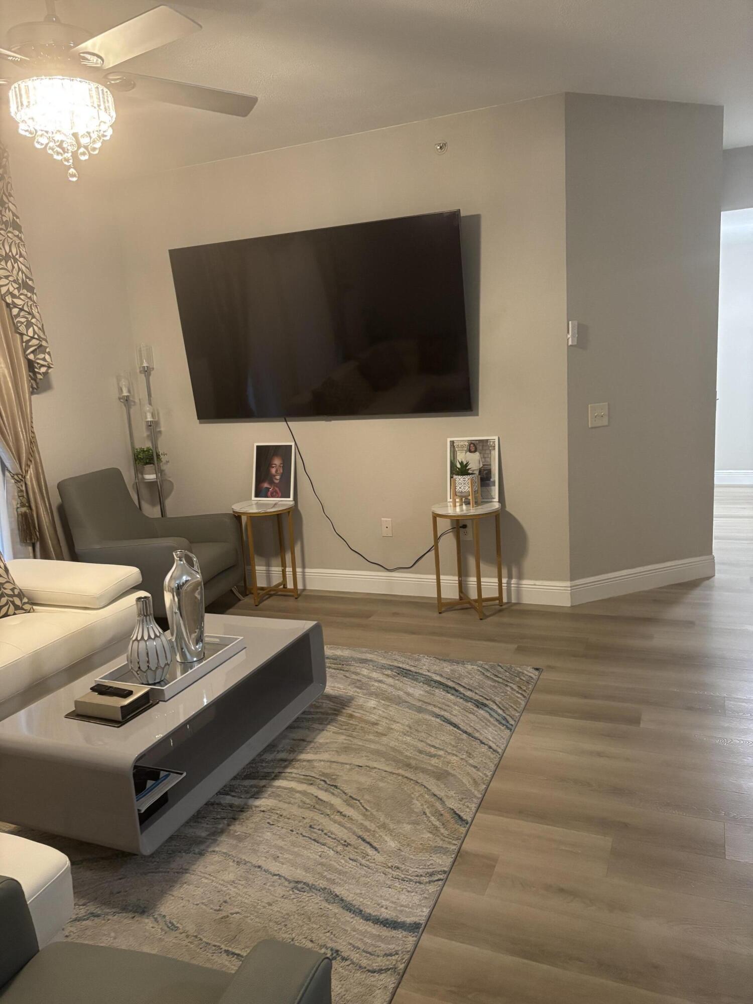 350 Crestwood Circle, Unit 106 Royal Palm Beach, FL 33411 - Photo 7 of 28 a living room with furniture and a flat screen tv