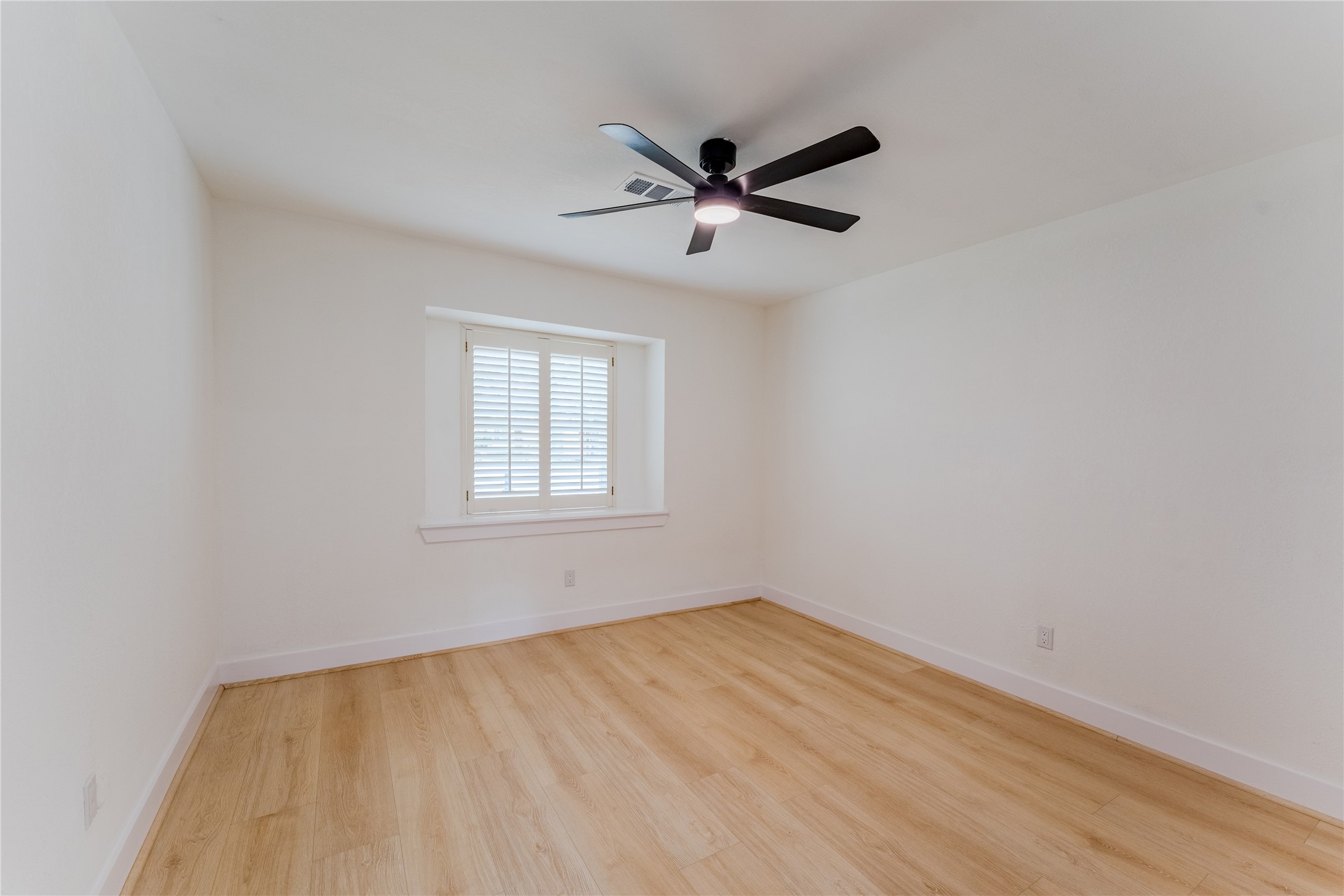 6027 Valkeith Drive Houston, TX 77096 - Photo 23 of 31 a view of an empty room with wooden floor and a window