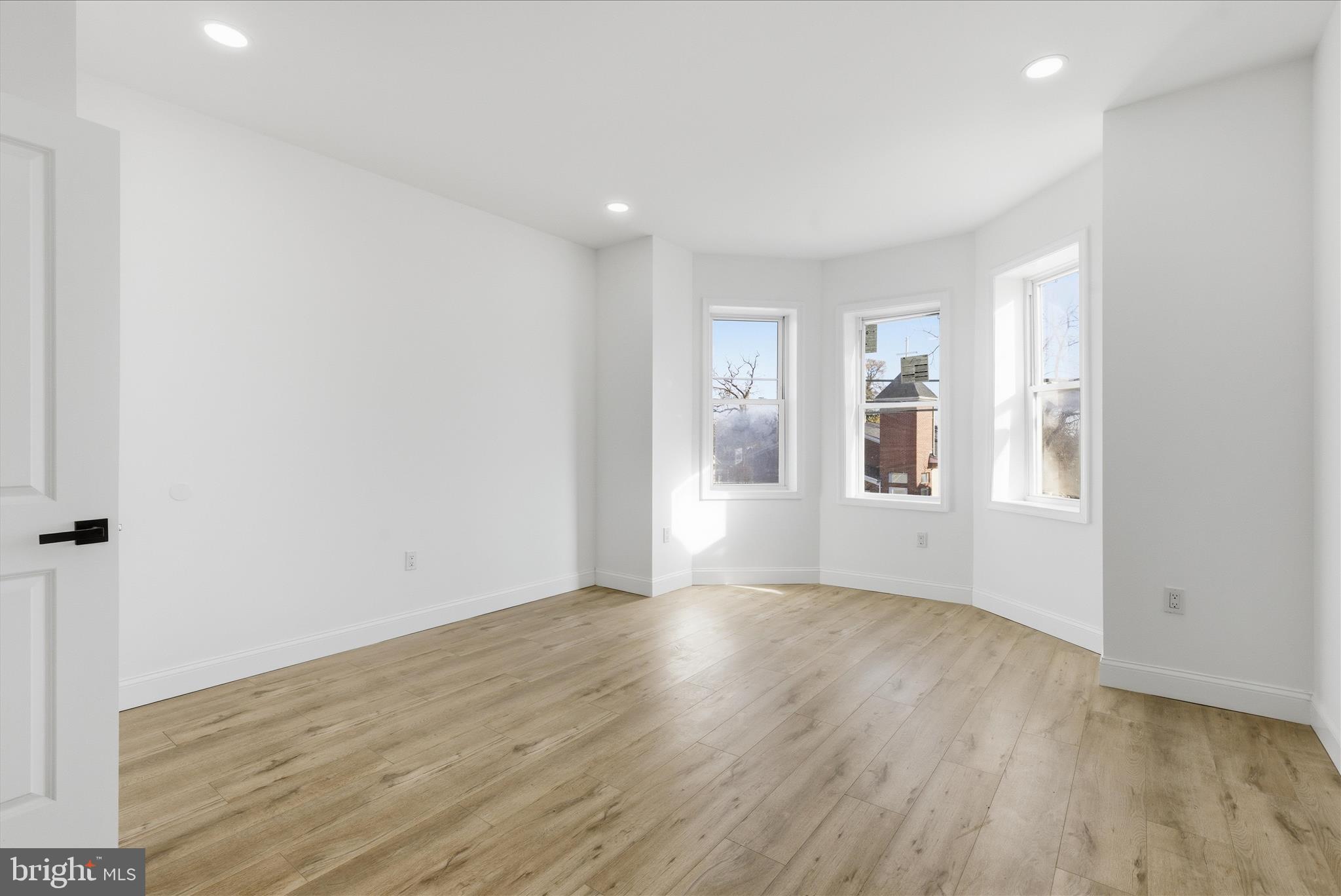 4668 Pimlico Road Baltimore, MD 21215 - Photo 11 of 32 a view of an empty room with wooden floor and a window