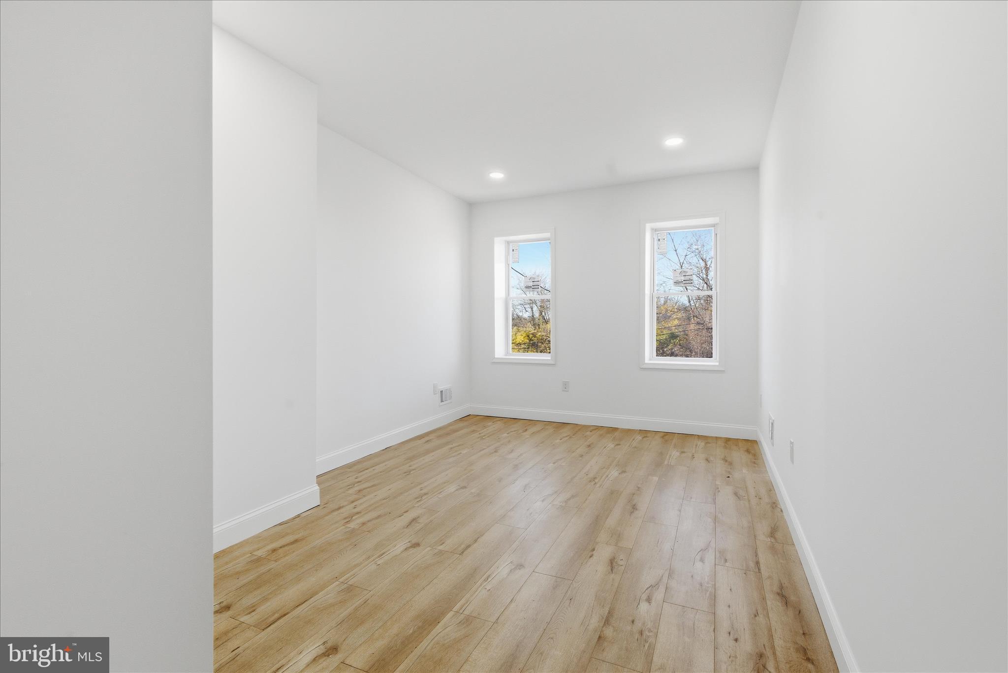 4668 Pimlico Road Baltimore, MD 21215 - Photo 14 of 32 an empty room with wooden floor and windows