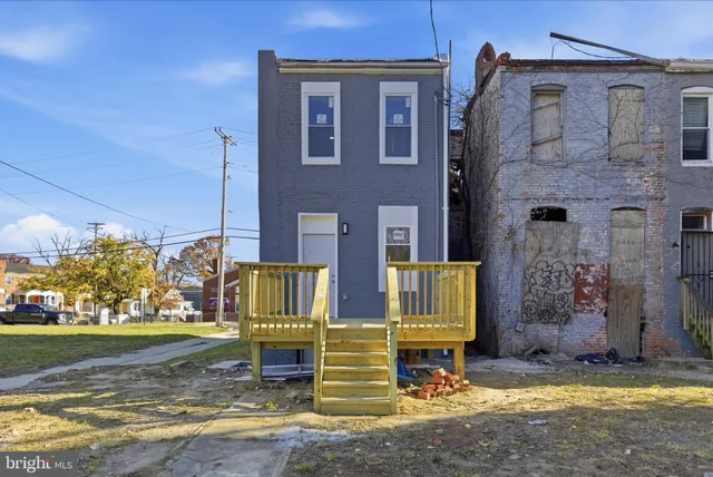 a view of the door of the house with a yard