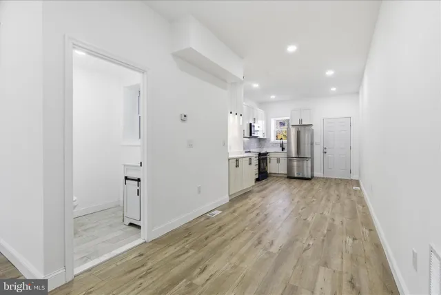 a view of a kitchen with a sink and refrigerator