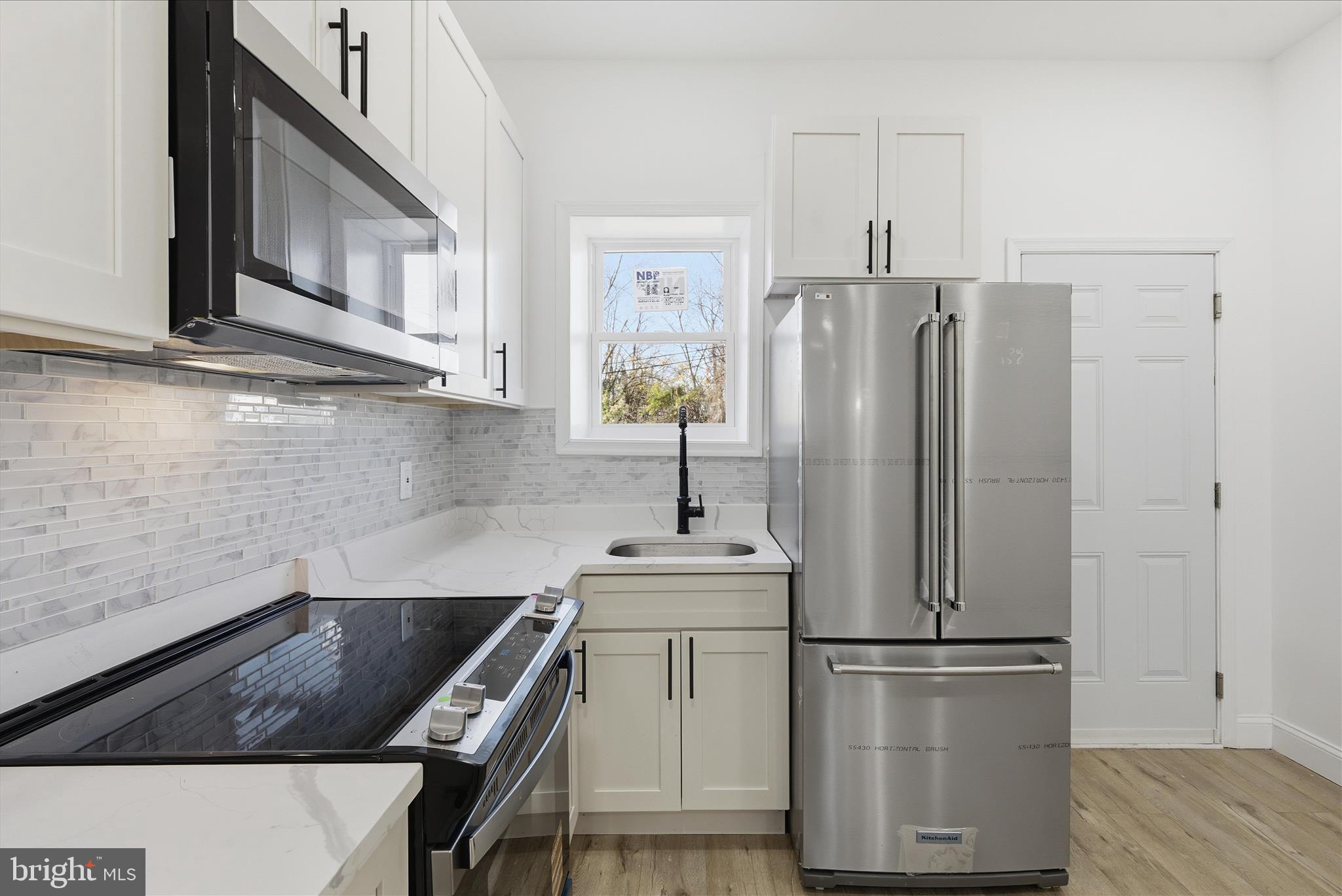 4668 Pimlico Road Baltimore, MD 21215 - Photo 7 of 32 a kitchen with a refrigerator sink and cabinets