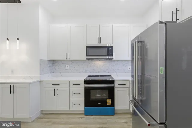 a kitchen with stainless steel appliances granite countertop a refrigerator and a stove top oven