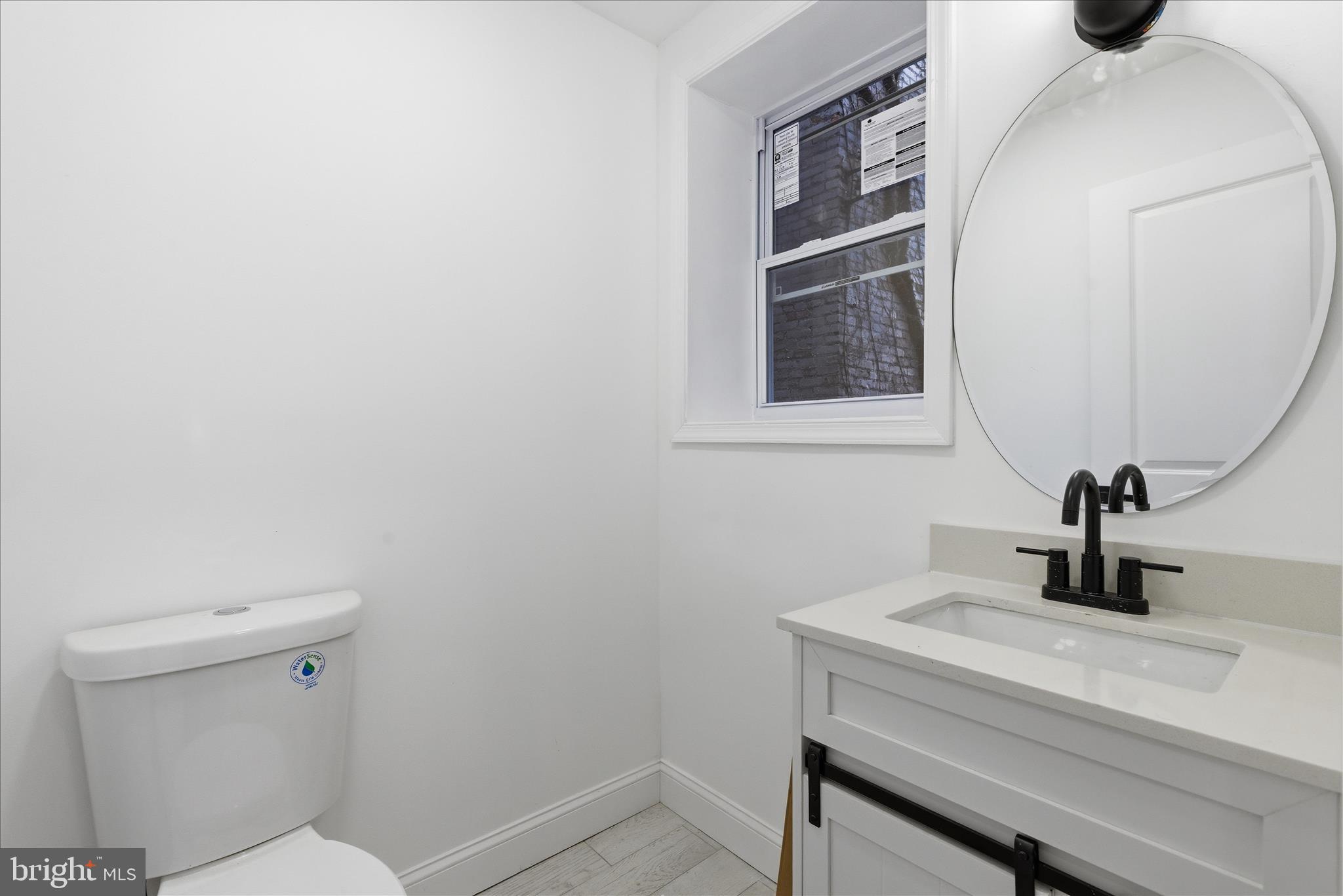 4668 Pimlico Road Baltimore, MD 21215 - Photo 9 of 32 a bathroom with a toilet sink and mirror