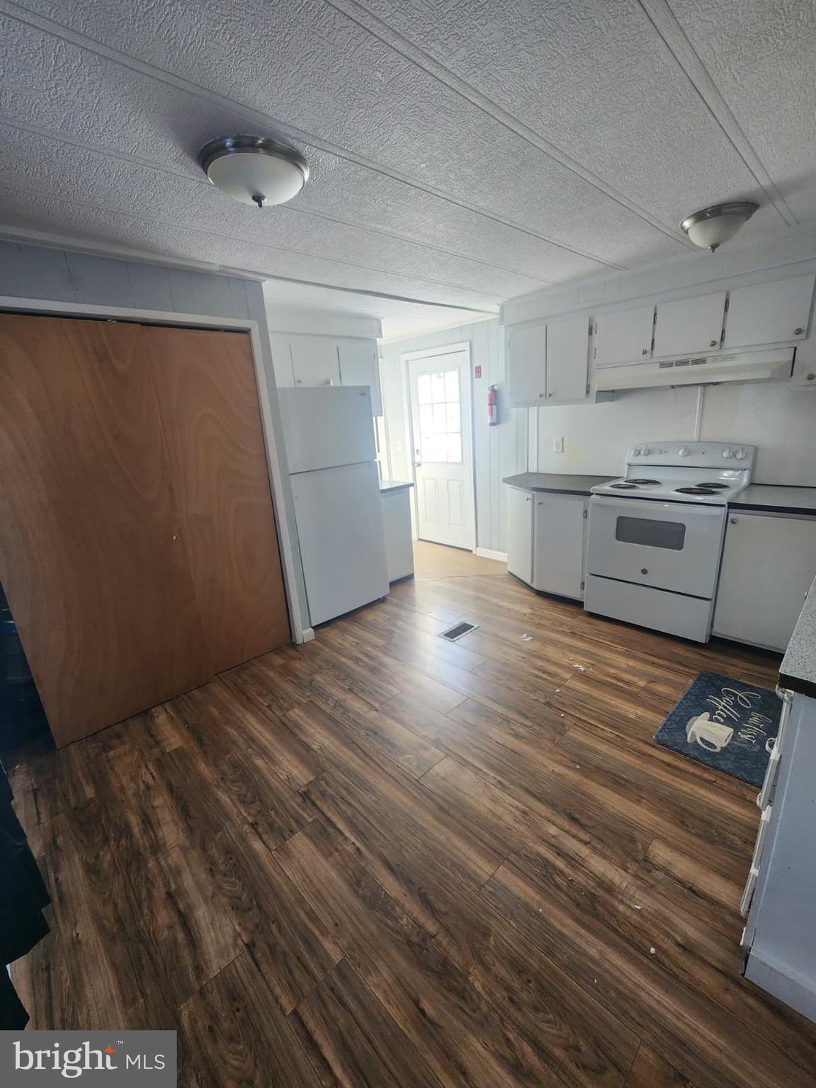 4191 Lake Road, Unit 28 Newfield, NJ 08344 - Photo 8 of 12 a kitchen with stainless steel appliances wooden floors and view living room