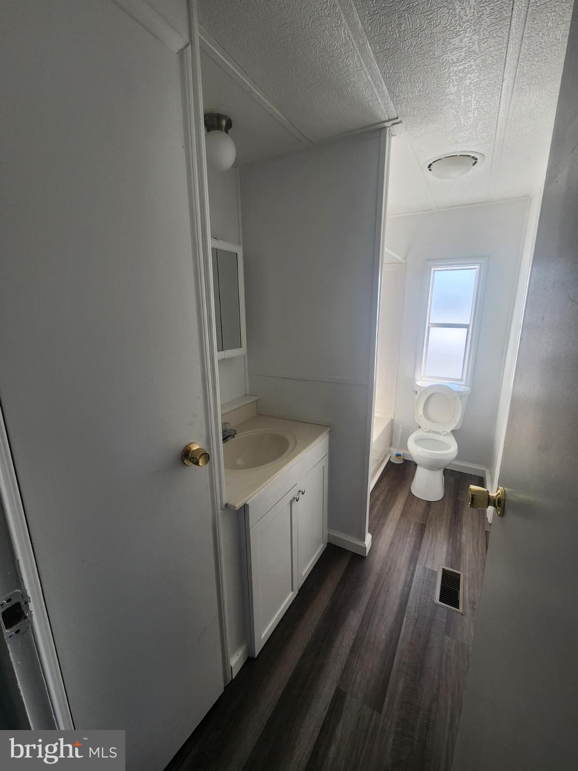 4191 Lake Road, Unit 28 Newfield, NJ 08344 - Photo 10 of 12 a bathroom with a sink a toilet and shower